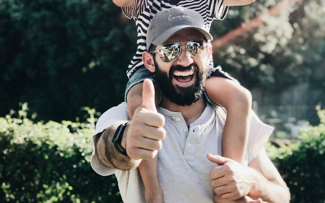 a father carrying his son over his shoulders